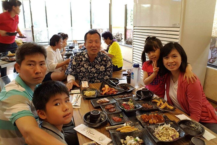 Savor delicious local cuisine with family and friends in a cozy Jeju restaurant surrounded by warm smiles and the essence of island life. Experience the true flavors of Jeju together.